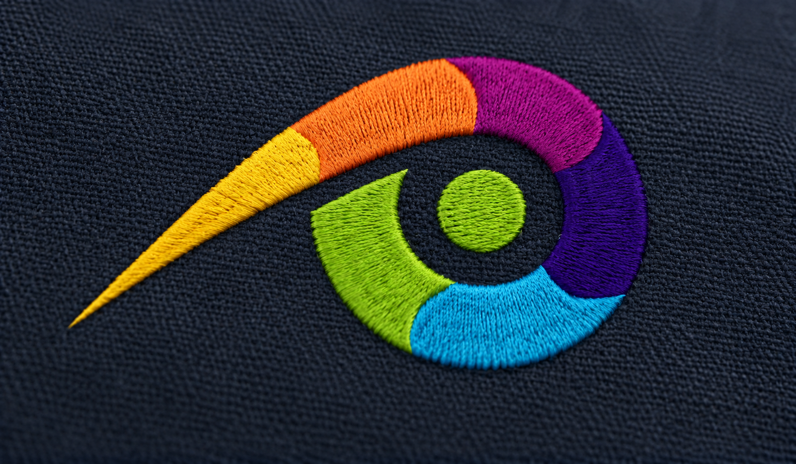 Detalle del logo multicolor de Privileggio bordado sobre tela azul marino